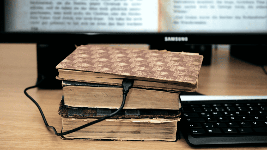 Créer un site internet d'auteur : Un livre ancien branché à un ordinateur par un câble de charge pour illustrer un site internet d'auteur - WenDev