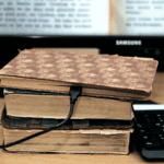 Créer un site internet d'auteur : Un livre ancien branché à un ordinateur par un câble de charge pour illustrer un site internet d'auteur - WenDev